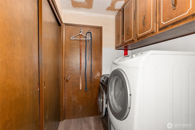 washroom featuring wood finished floors, cabinet space, and separate washer and dryer