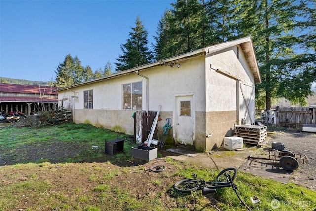 back of house with fence and stucco siding