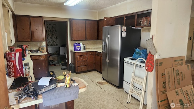 kitchen with electric stove, dark brown cabinets, light countertops, stainless steel fridge with ice dispenser, and light floors