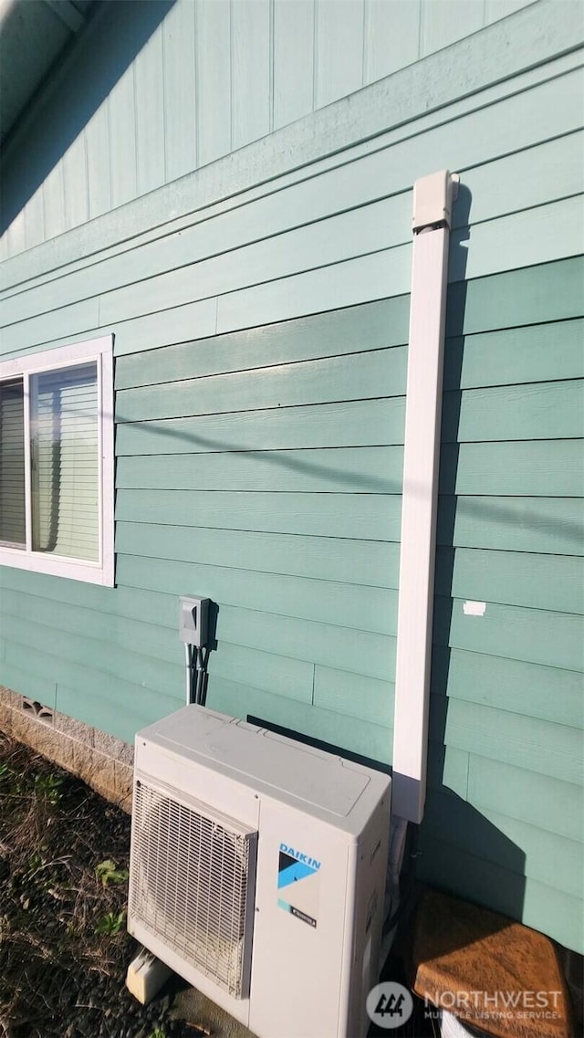 exterior details featuring board and batten siding, ac unit, and crawl space