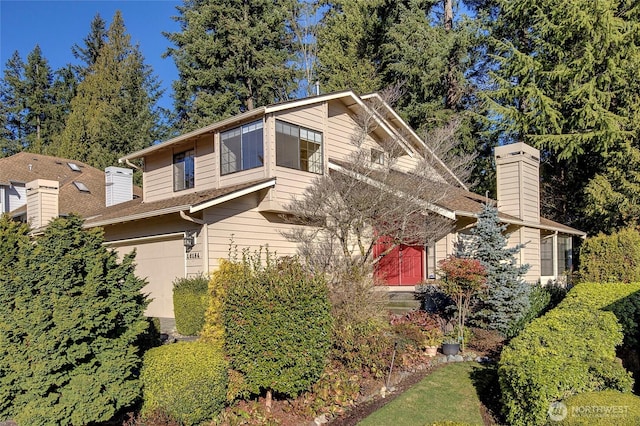 view of home's exterior with a garage and a chimney