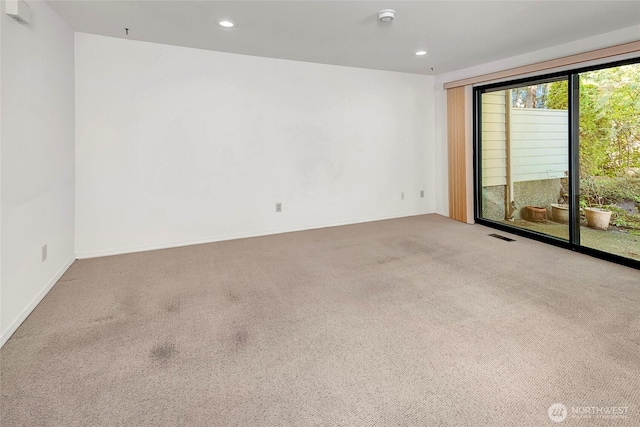 spare room featuring carpet, visible vents, and recessed lighting