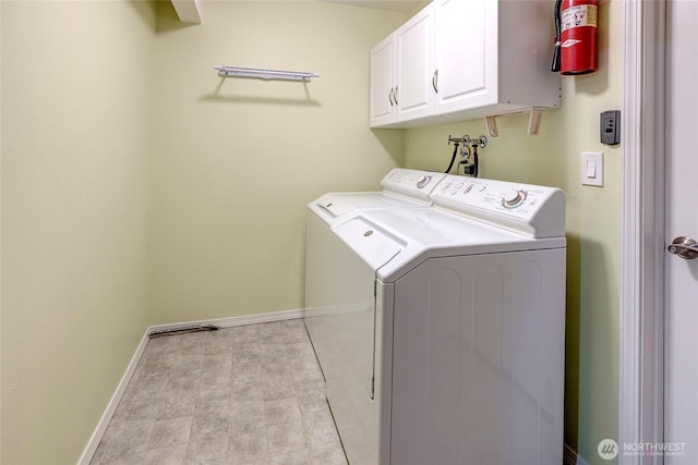 laundry area with cabinet space, baseboards, and washer and clothes dryer