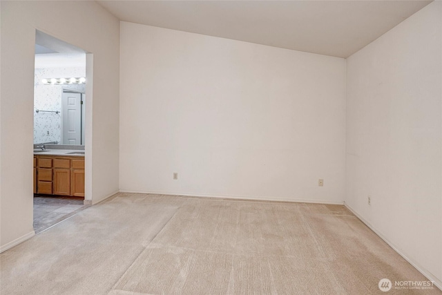 unfurnished bedroom with light colored carpet and ensuite bathroom