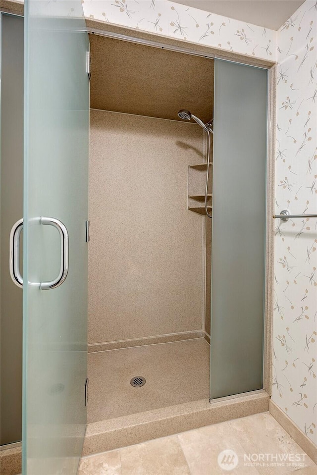 full bathroom with baseboards, a stall shower, and wallpapered walls