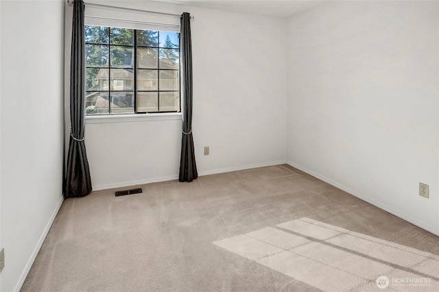 carpeted empty room featuring visible vents and baseboards