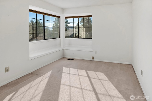 carpeted spare room with visible vents and baseboards