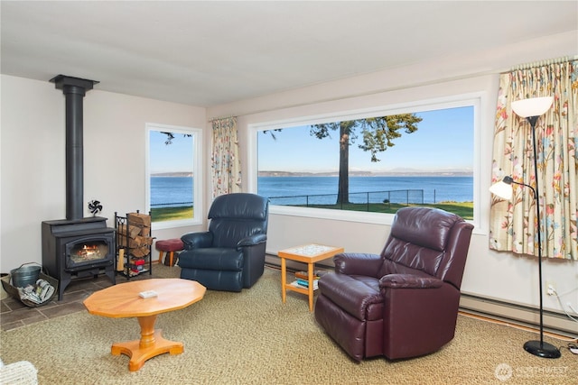 sitting room featuring a water view, a wood stove, and a baseboard radiator