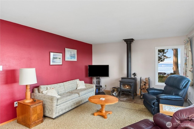 living area with stone finish floor, baseboards, and a wood stove