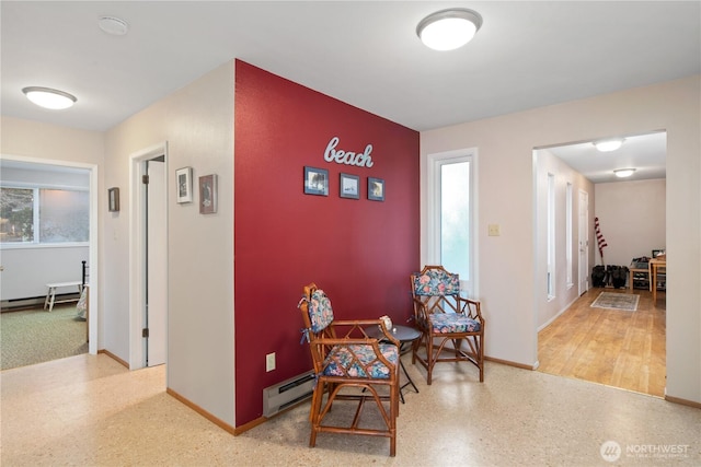 hallway with a baseboard radiator and baseboards