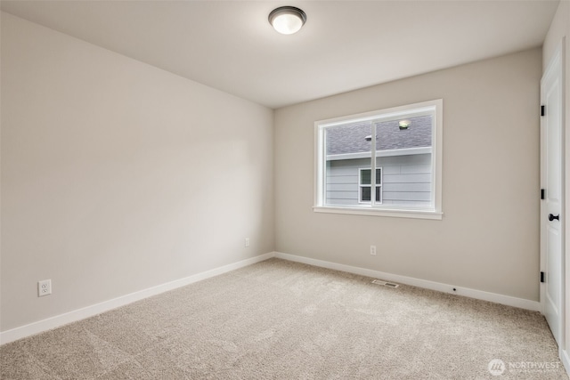 empty room featuring baseboards, visible vents, and carpet