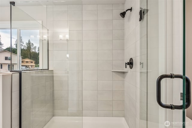 bathroom with a shower stall and plenty of natural light