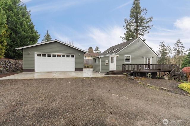 ranch-style house with an outbuilding, a detached garage, and a wooden deck