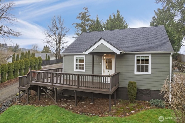 exterior space with roof with shingles and a deck