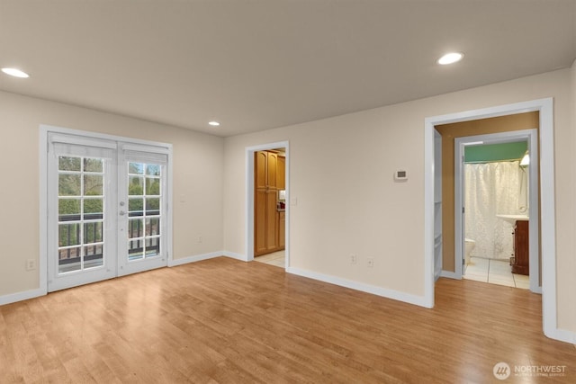 spare room with recessed lighting, light wood-style flooring, baseboards, and french doors