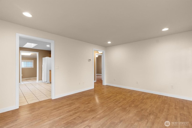 empty room with baseboards, light wood-type flooring, and recessed lighting