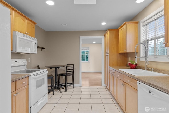 kitchen with light tile patterned floors, white appliances, a sink, and a healthy amount of sunlight