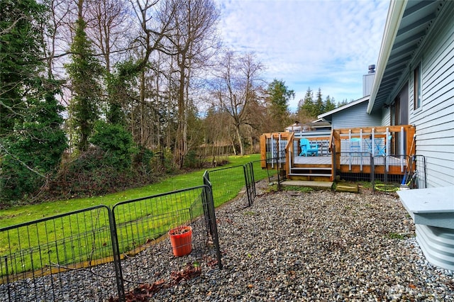 view of yard with a wooden deck, a gate, and fence