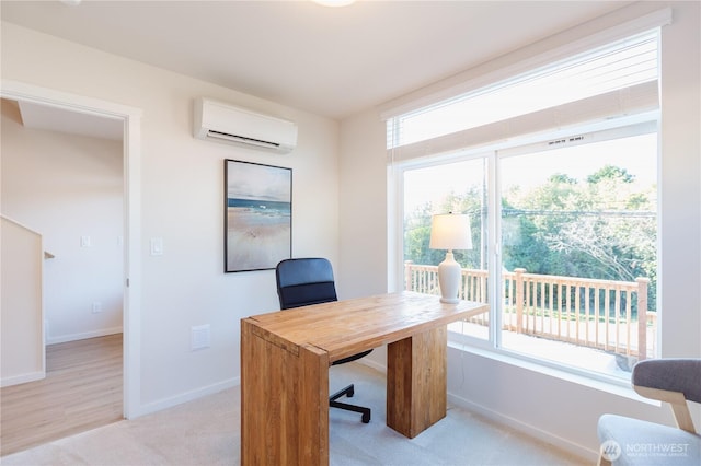 office space featuring a wall mounted AC, plenty of natural light, light colored carpet, and baseboards