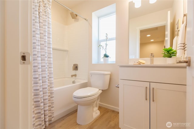 full bath featuring toilet, wood finished floors, vanity, baseboards, and shower / bathtub combination with curtain