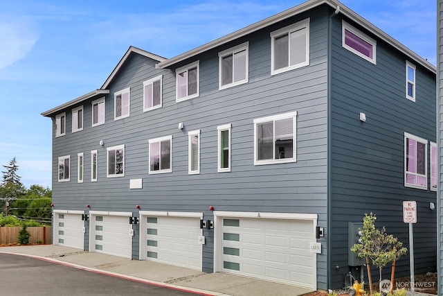 view of front of house with an attached garage and fence