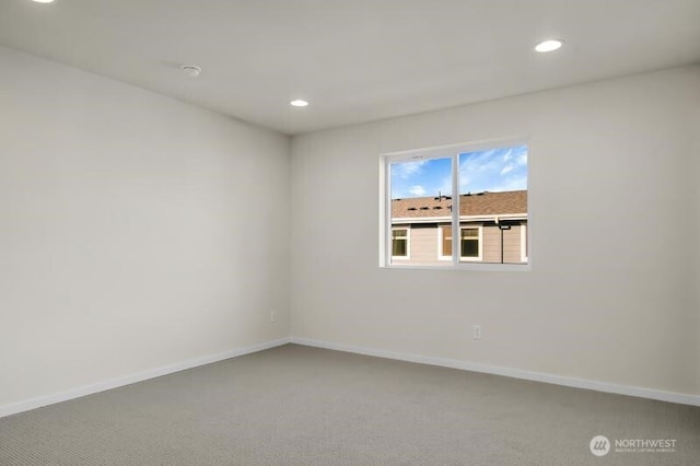 empty room with carpet floors, recessed lighting, and baseboards