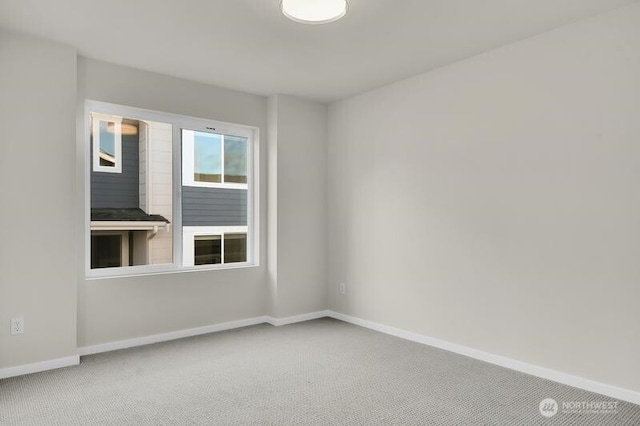 spare room featuring carpet floors and baseboards