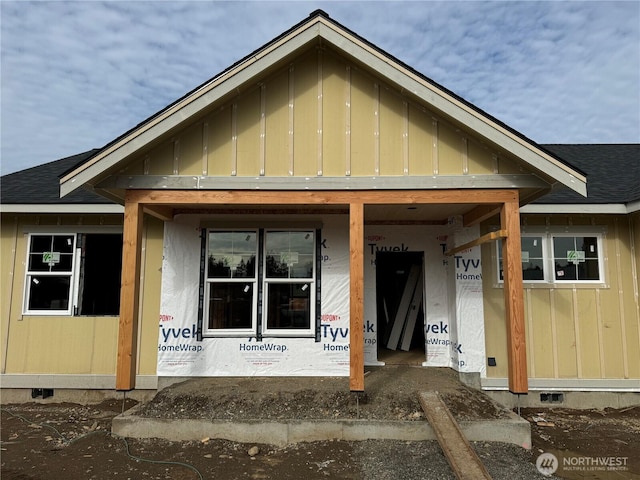 exterior space with board and batten siding, crawl space, and roof with shingles