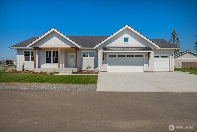 view of front of home featuring a standing seam roof, a garage, driveway, roof with shingles, and a front lawn