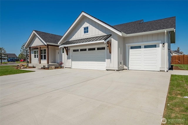 view of front of home with board and batten siding, a standing seam roof, a garage, roof with shingles, and concrete driveway