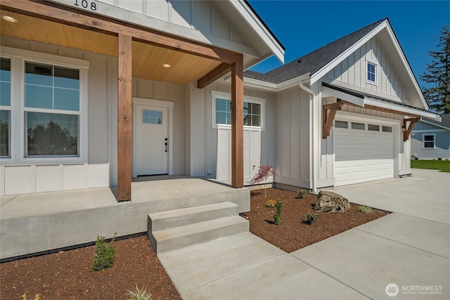 entrance to property with concrete driveway, covered porch, a shingled roof, and board and batten siding
