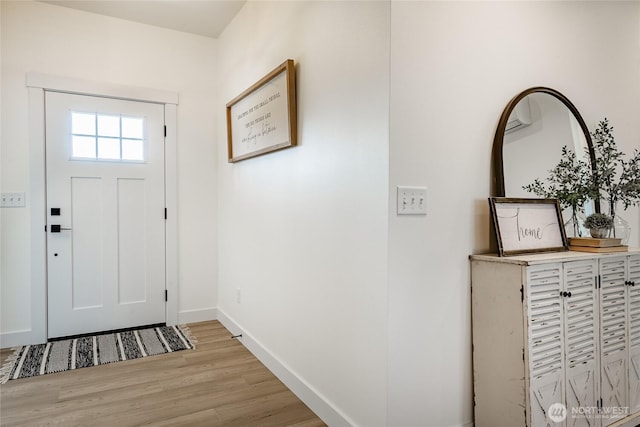 foyer featuring baseboards and light wood-style floors