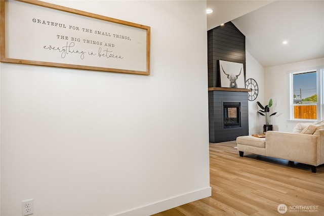 living room with recessed lighting, wood finished floors, a large fireplace, baseboards, and lofted ceiling