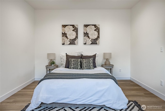 bedroom with wood finished floors and baseboards