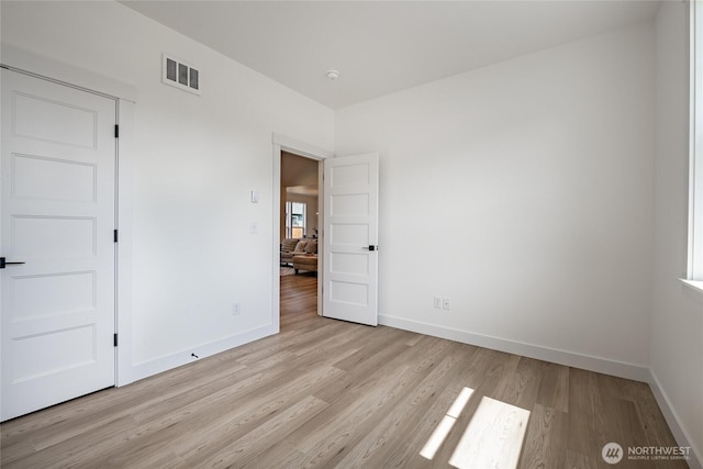 unfurnished bedroom featuring visible vents, light wood-style flooring, and baseboards