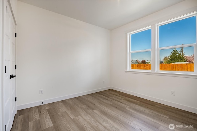 spare room with light wood-style flooring and baseboards