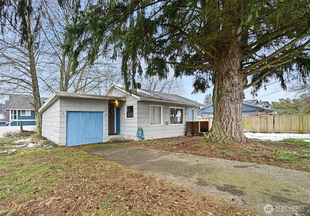 view of front of home featuring a garage, a chimney, fence, and aphalt driveway