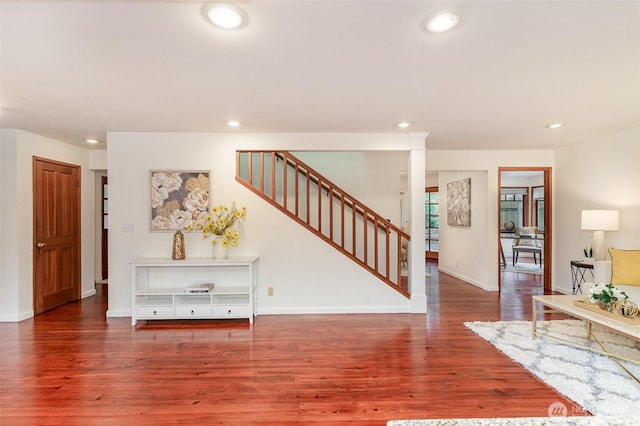 foyer entrance featuring stairs, baseboards, wood finished floors, and recessed lighting