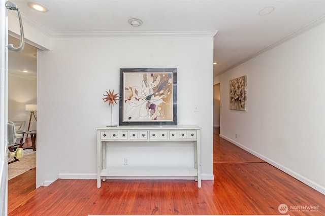 corridor with crown molding and wood finished floors