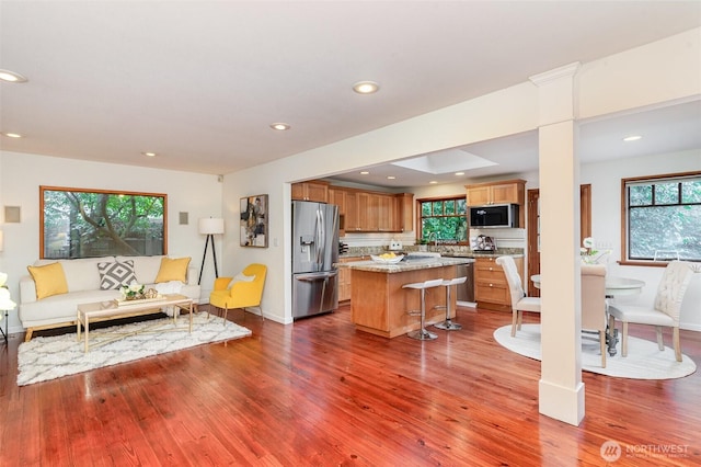 kitchen with a center island, recessed lighting, appliances with stainless steel finishes, dark wood-type flooring, and open floor plan