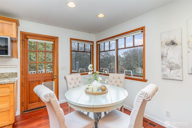 dining area with baseboards, visible vents, wood finished floors, and recessed lighting