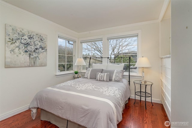 bedroom with crown molding, baseboards, and wood finished floors