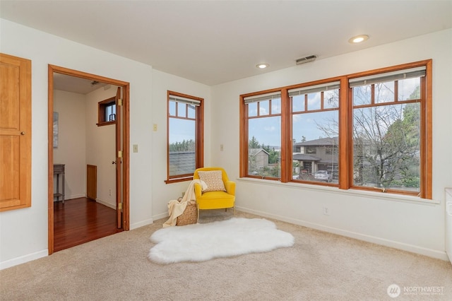 unfurnished room featuring baseboards, carpet, visible vents, and a healthy amount of sunlight