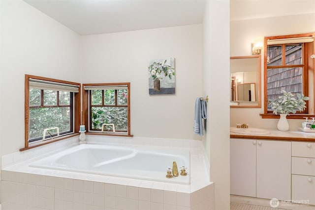 bathroom featuring a garden tub and vanity