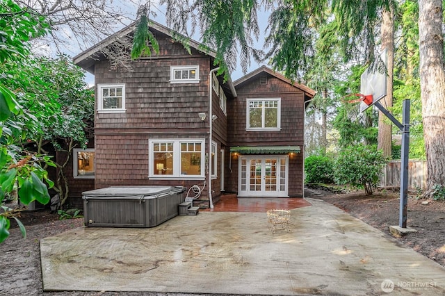 back of property with french doors, a patio, and a hot tub