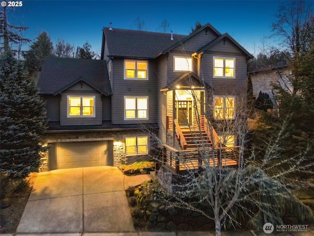 craftsman-style house featuring an attached garage, stone siding, driveway, and stairs