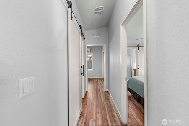 1000 Sr 150, Manson, WA 98831 - corridor with wood finished floors, a barn door, visible vents, and baseboards