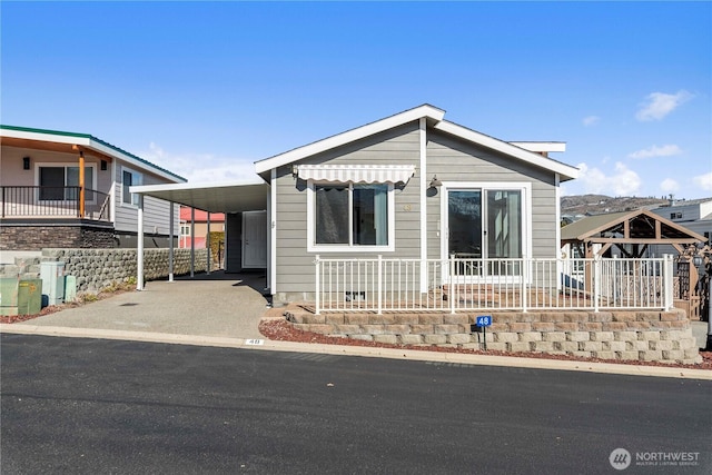 view of front of home featuring driveway, a porch, and an attached carport