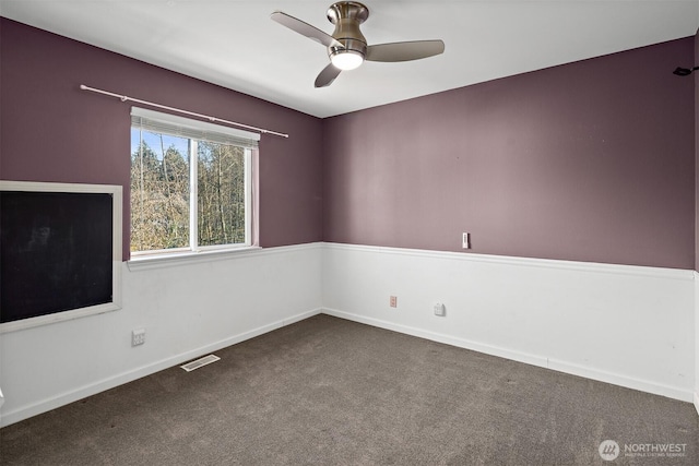 carpeted empty room featuring visible vents, ceiling fan, and baseboards