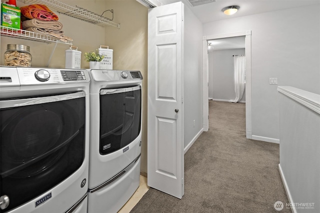 laundry area with washing machine and clothes dryer, visible vents, light colored carpet, laundry area, and baseboards